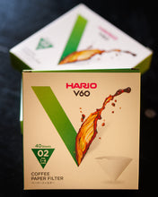 Load image into Gallery viewer, Hario V60 coffee paper filter box on a dark textured surface