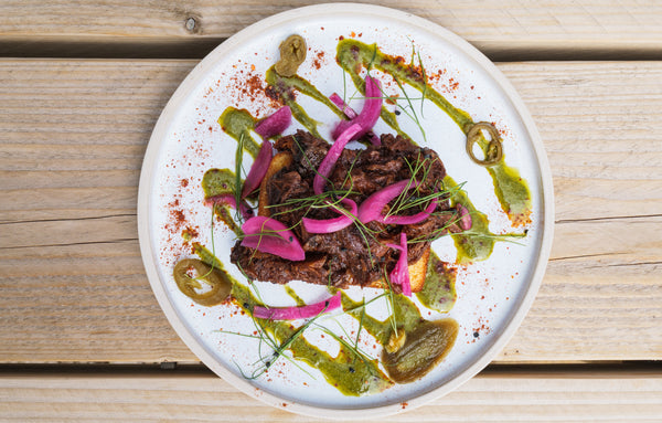 Beef Birria Cornbread served with pickled red onion and tahini dressing