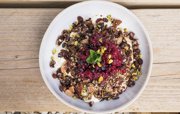 Bowl of granola with greek yogurt and a mixed berry compote