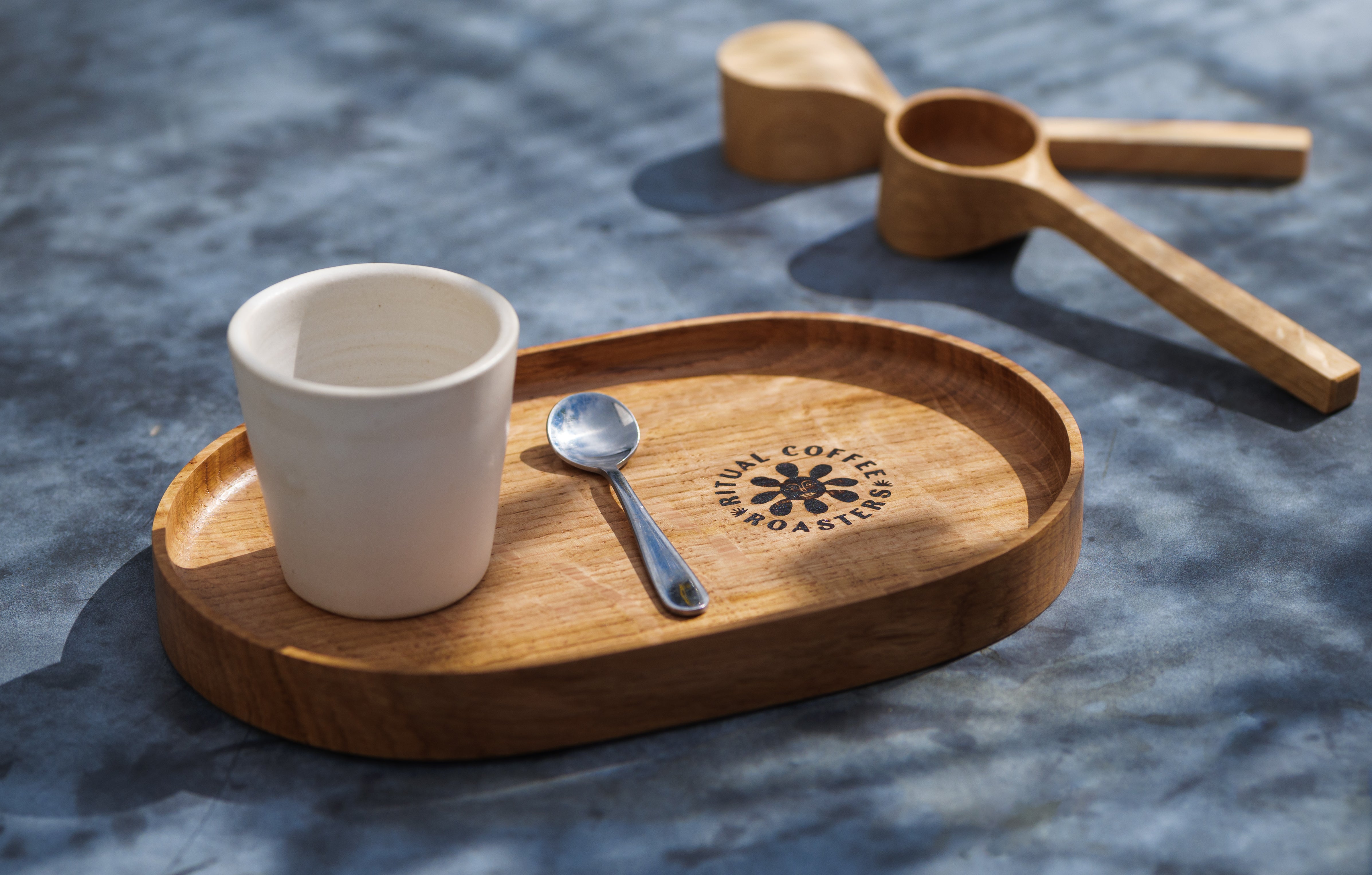 Handmade oak tray with Ritual Coffee symbol embossed with a cup and spoon on it.